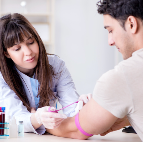 phlebotomist drawing blood from man