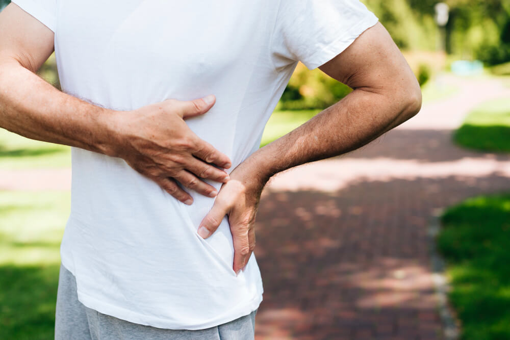man holding himself in pain from kidney stones